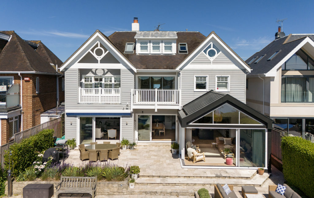 Complete house view showing white frame sliding system installation across ground floor